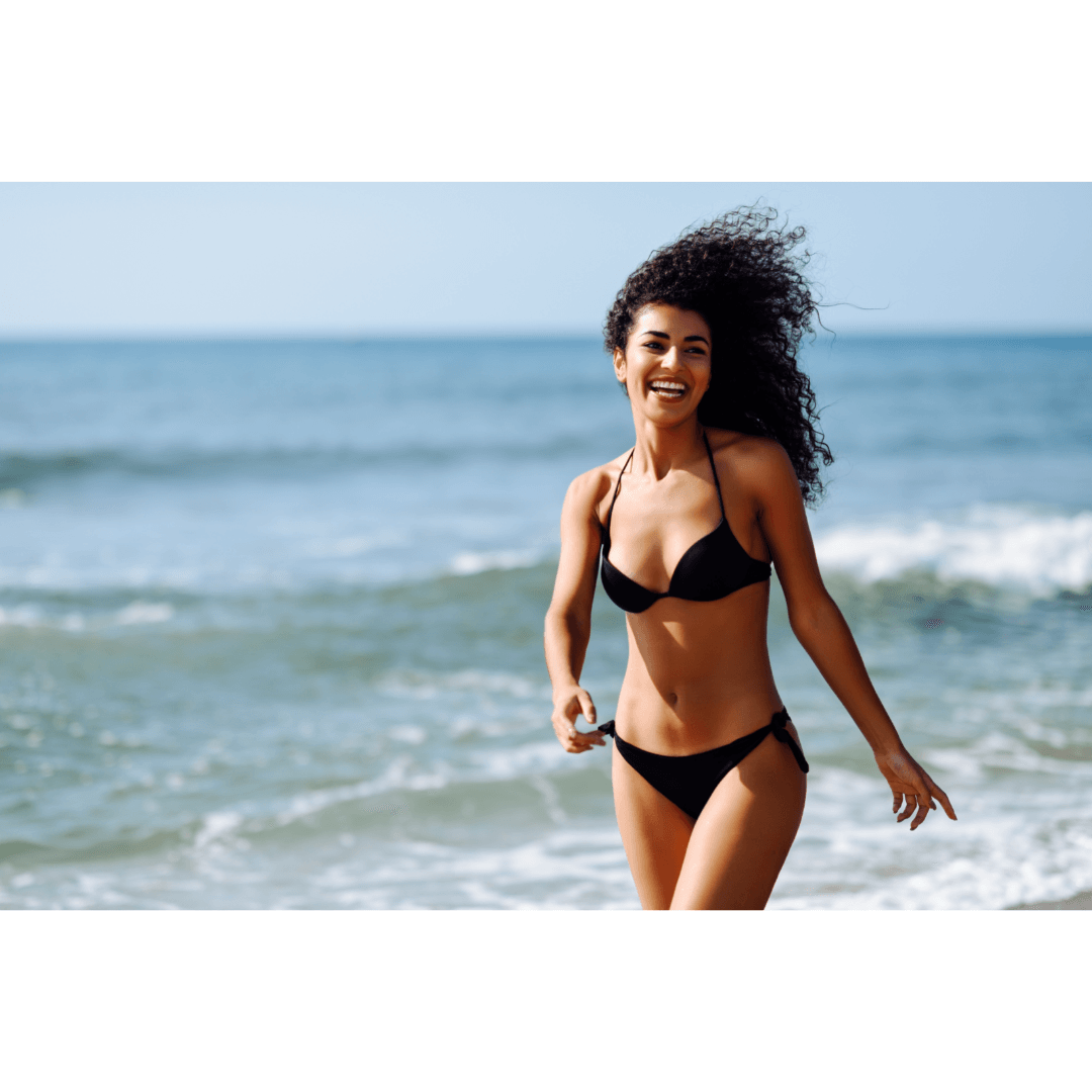 a woman in a bikini walking on the beach