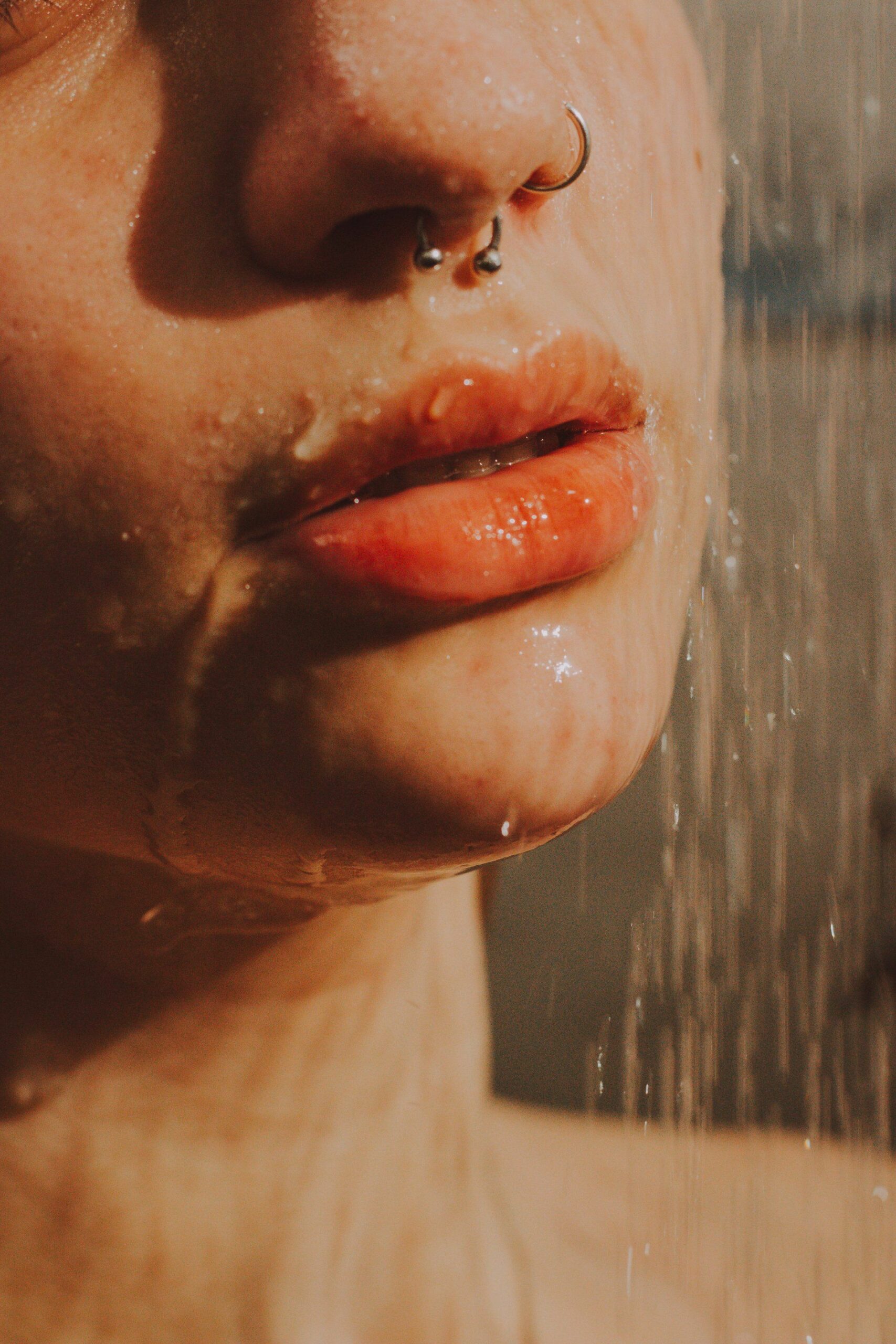 A woman's lips getting wet while standing in the shower