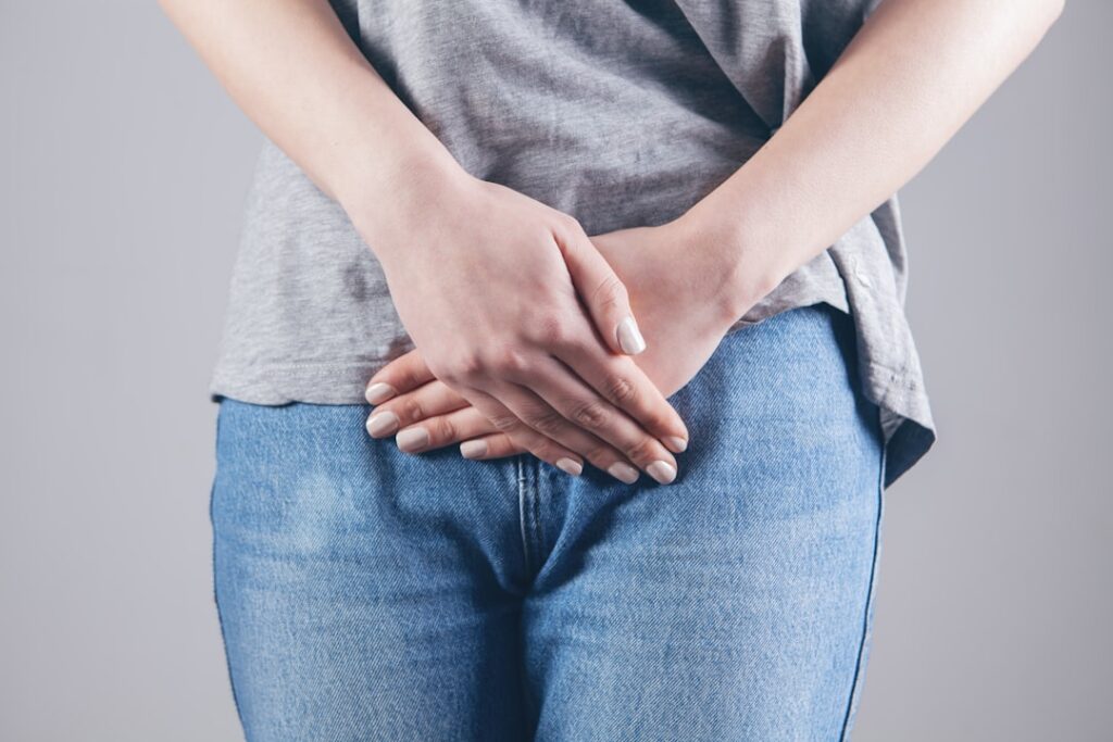 woman in gray shirt and blue denim jeans. liposuction after weight loss